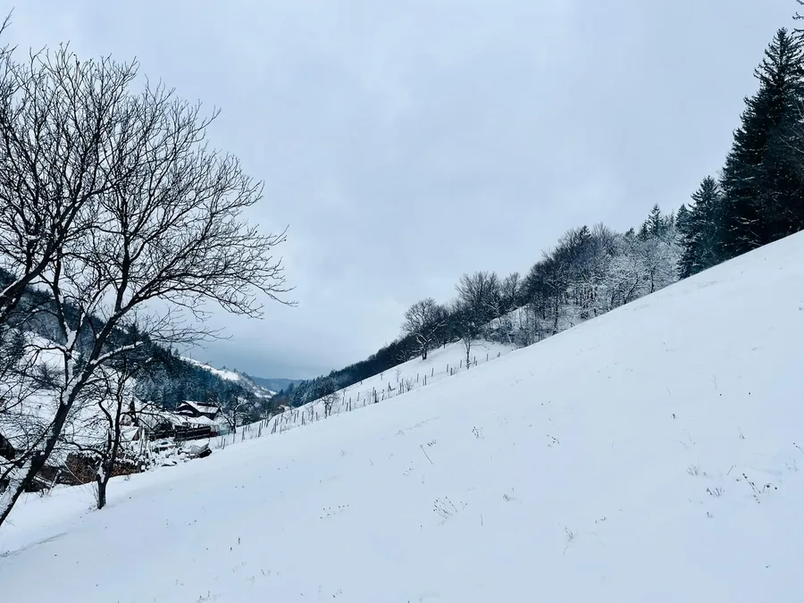 Winter landscape with fresh snow on the hills around the house